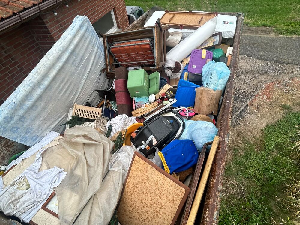 Een aanhangwagen geladen met huisraad uit een woning.